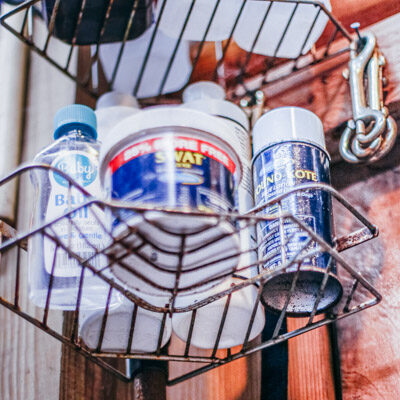 Rusty shower tower holding horse medicines in a barn.